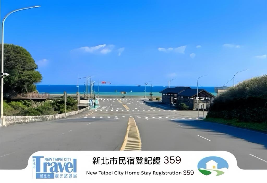 an empty street with the ocean in the background at Shan Cheng Guesthouse in Ruifang