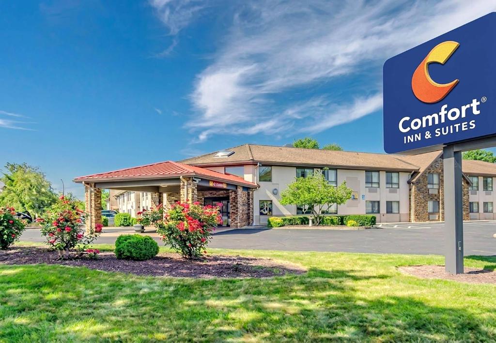 a hotel sign in front of a building with a comfort inn and suites at Comfort Inn & Suites West Springfield in West Springfield