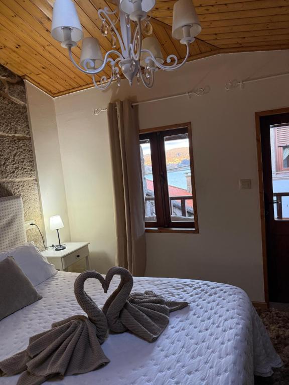 a bedroom with two swans towels on a bed at Vida Entre Balcones in Combarro