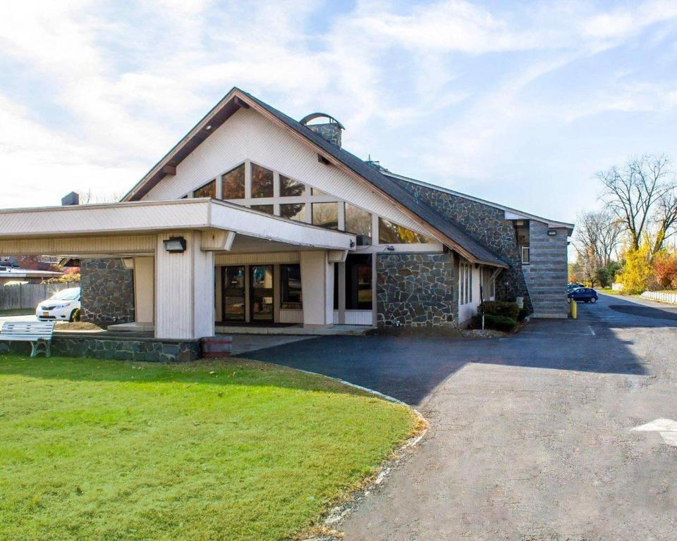 a home with a stone house with a driveway at Econo Lodge Inn & Suites Colonie Center Mall in Albany