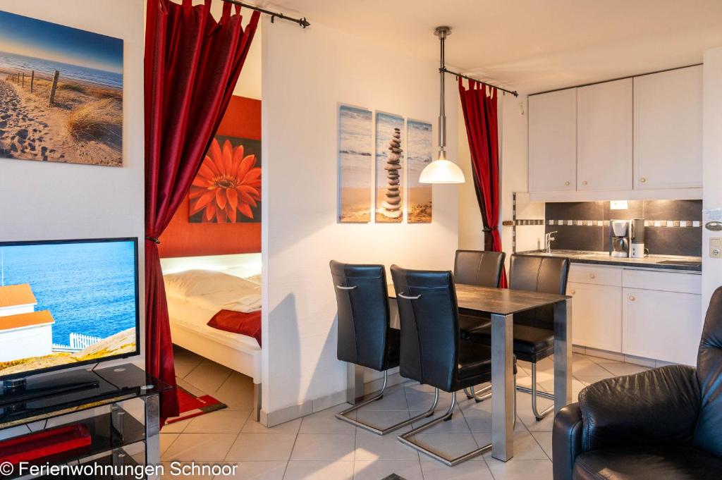 a living room with a dining room table and a bedroom at Ankerplatz 607 in Schilksee