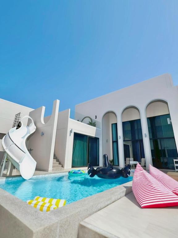 a pool at a resort with a water slide at Nacha Pool Villa Cha-am in Cha Am