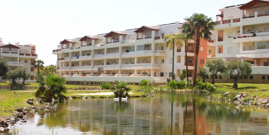 duży budynek mieszkalny położony obok zbiornika wodnego w obiekcie Benalmádena Del Mar Apartments w mieście Benalmádena