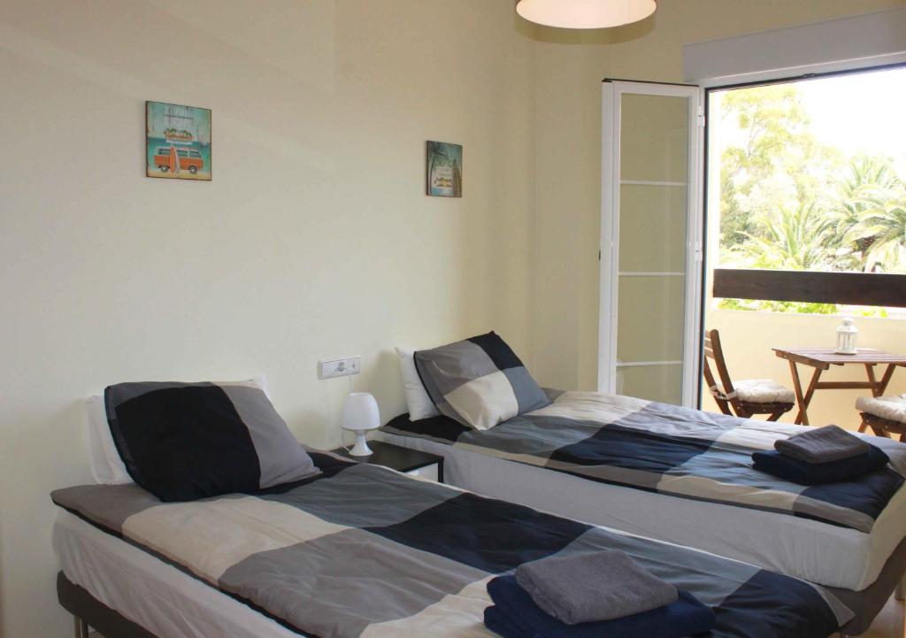2 łóżka w pokoju z balkonem w obiekcie Benalmádena Del Mar Apartments w mieście Benalmádena