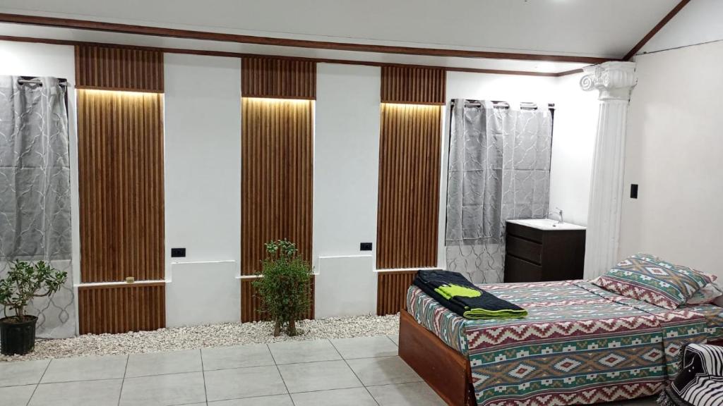 a bedroom with a bed and a couch in a room at Little Home in General Viejo