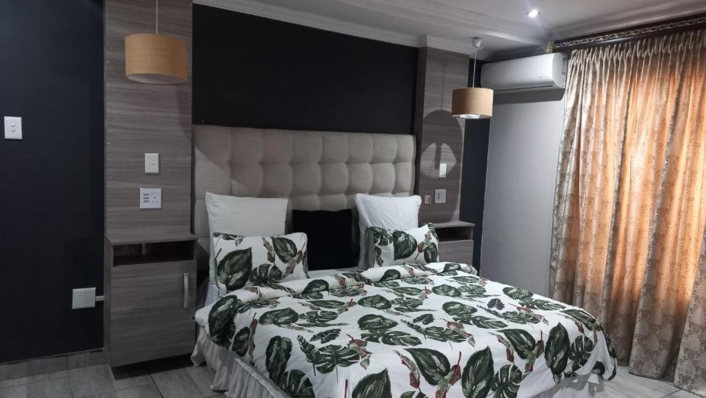 a bedroom with a bed with a green and white comforter at The Palace in Pretoria