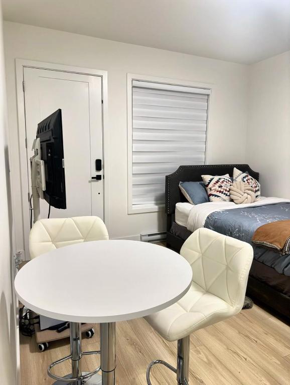 a room with a table and a bed and a tv at Quiet Private Room Victoria - PS5, Fast WiFi, Parking in Langford