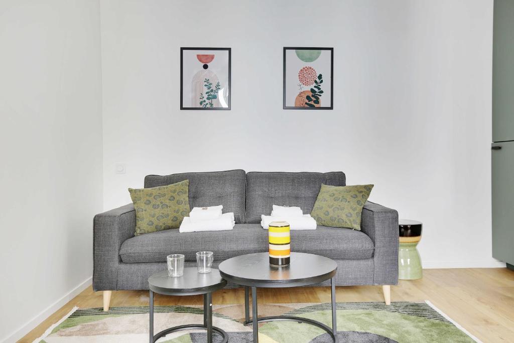 a living room with a gray couch and a table at Charming studio for 2P - near Parc Monceau in Paris