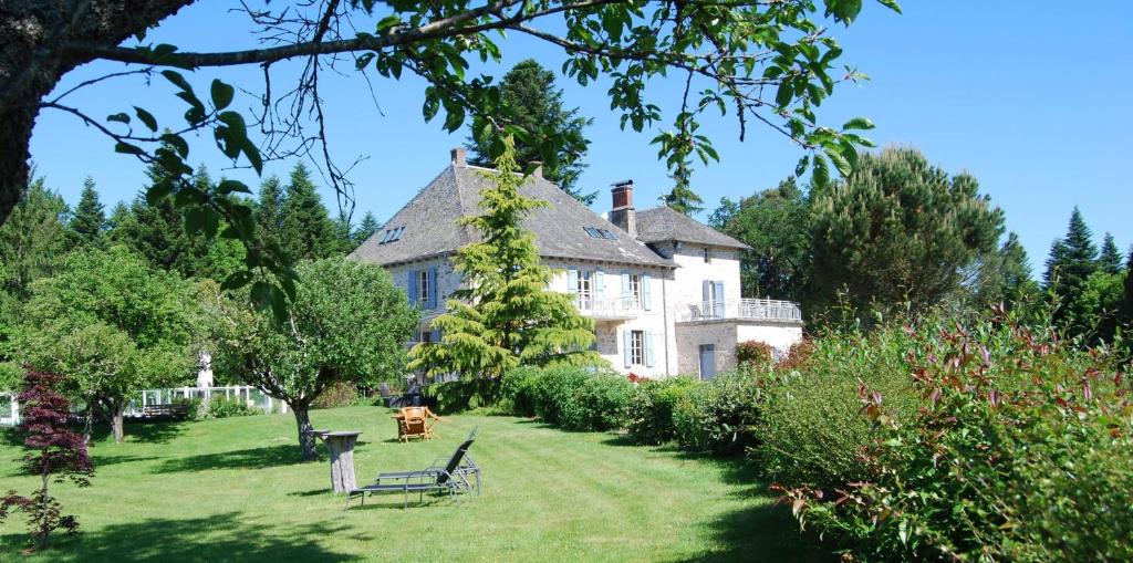 a large white house with a garden in front of it at Les Maisons de Concasty in Boisset