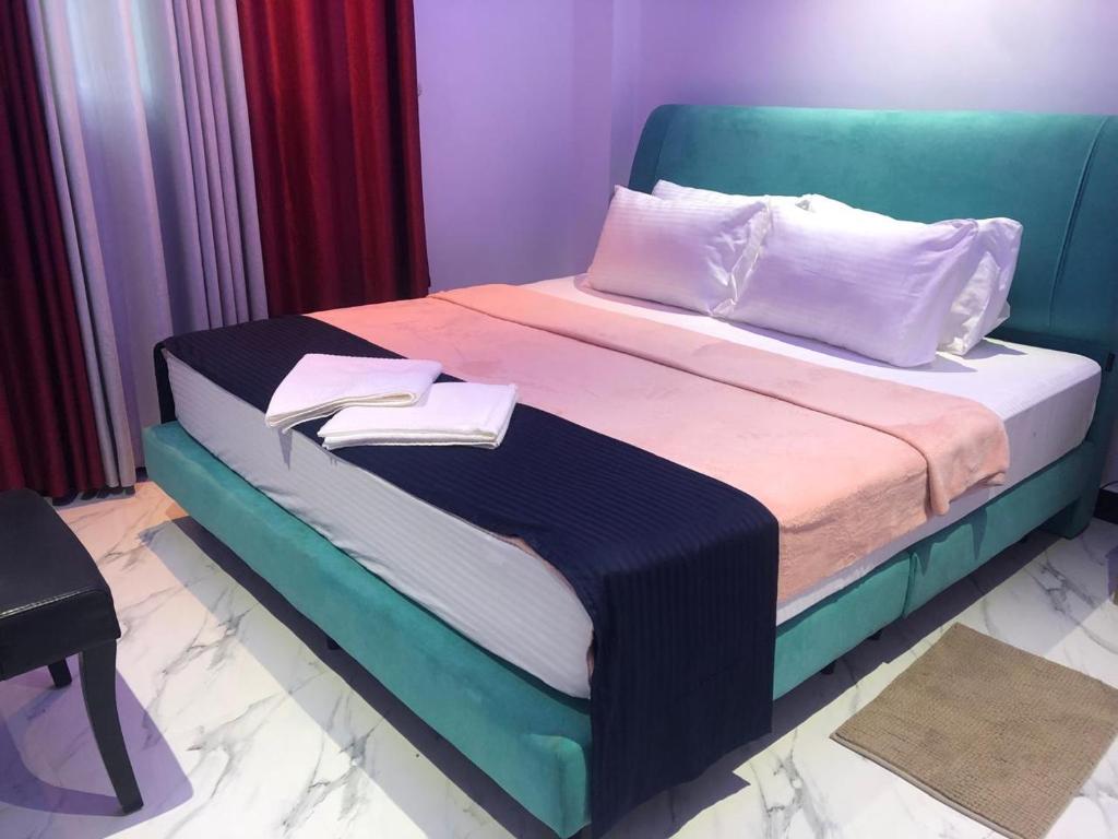 a bedroom with a bed with a blue head board at Sevmeth Villa in Kandy