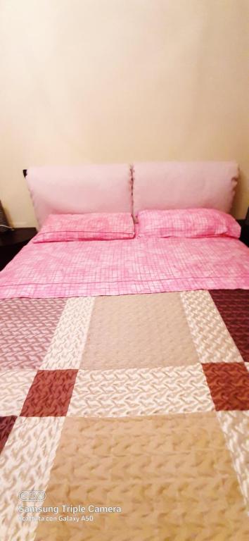 a bed with a quilt on it in a room at I sogni di viola in Saluzzo
