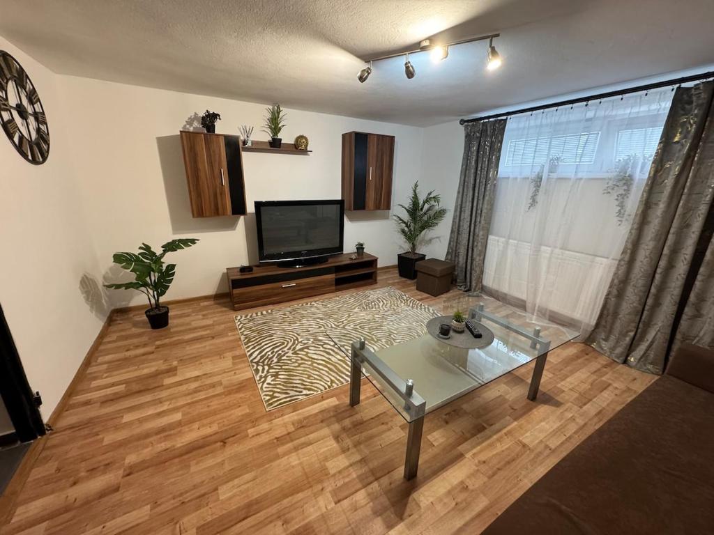 a living room with a television and a wooden floor at Apartment MBD in Veľká Mača