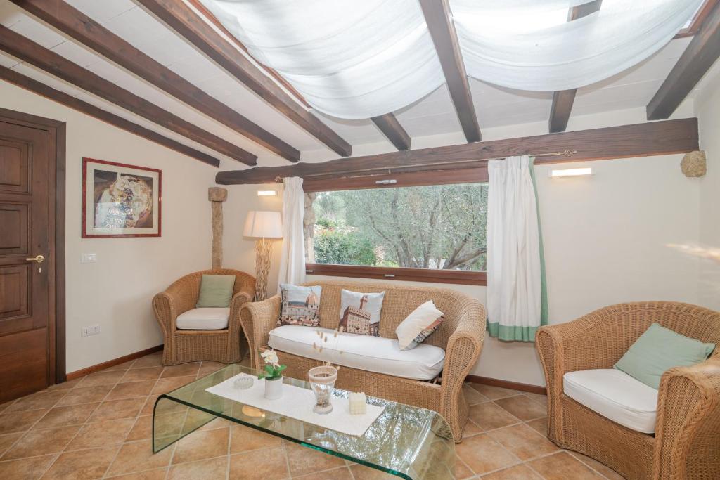 a living room with wicker furniture and a window at Residenza Conti Porto Istana in Porto Istana