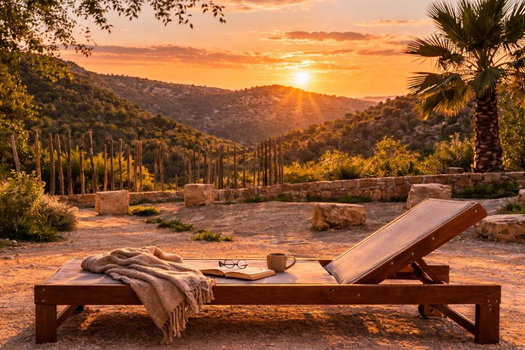 a picnic table with a blanket and a book and the sunset at Ribazos de la Sierra in Carmona