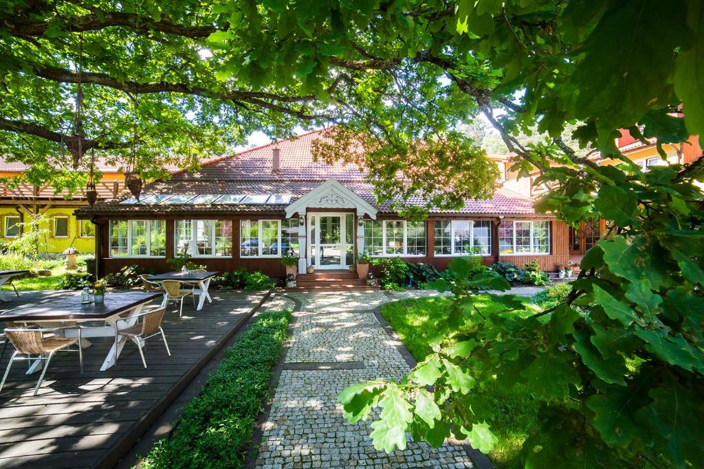 a garden with a table and chairs and a building at Wiatraki Nature Resort in Olsztynek