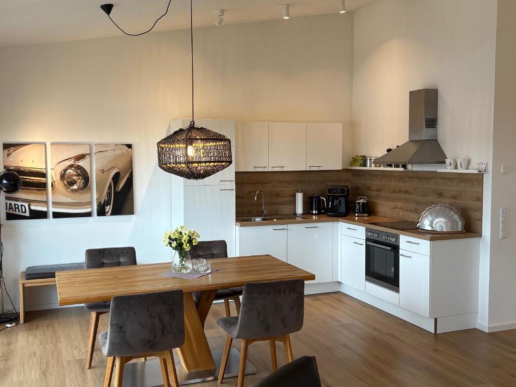 a kitchen with a wooden table and a dining room at Terralpin - Wohnen auf Zeit - DG Wohnung mit Bergblick in Bruckmühl