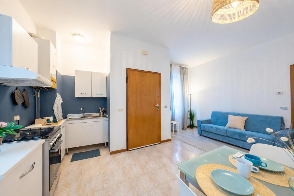 a kitchen and living room with a blue couch at Verdi Bilo Roseto Vacanza in Roseto degli Abruzzi