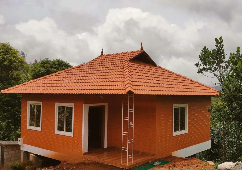a house being constructed with an orange roof at Alloos homestay villa in Attappādi