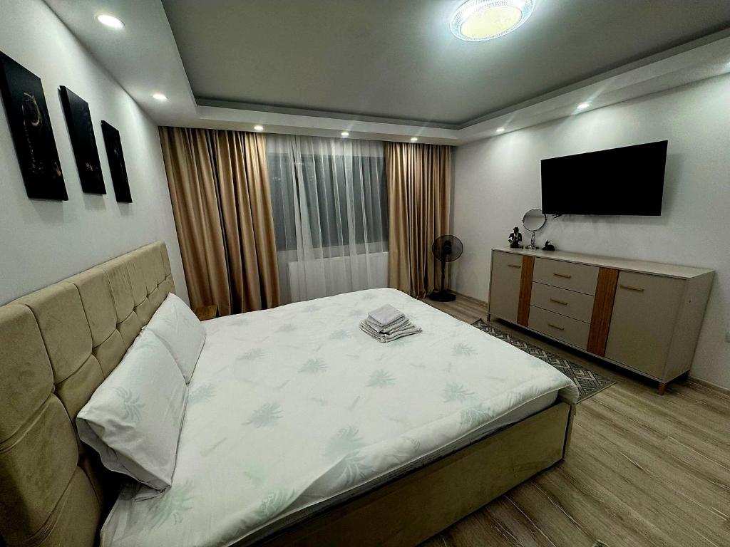 a bedroom with a bed and a flat screen tv at Cosy Vibe 3 in Vaslui