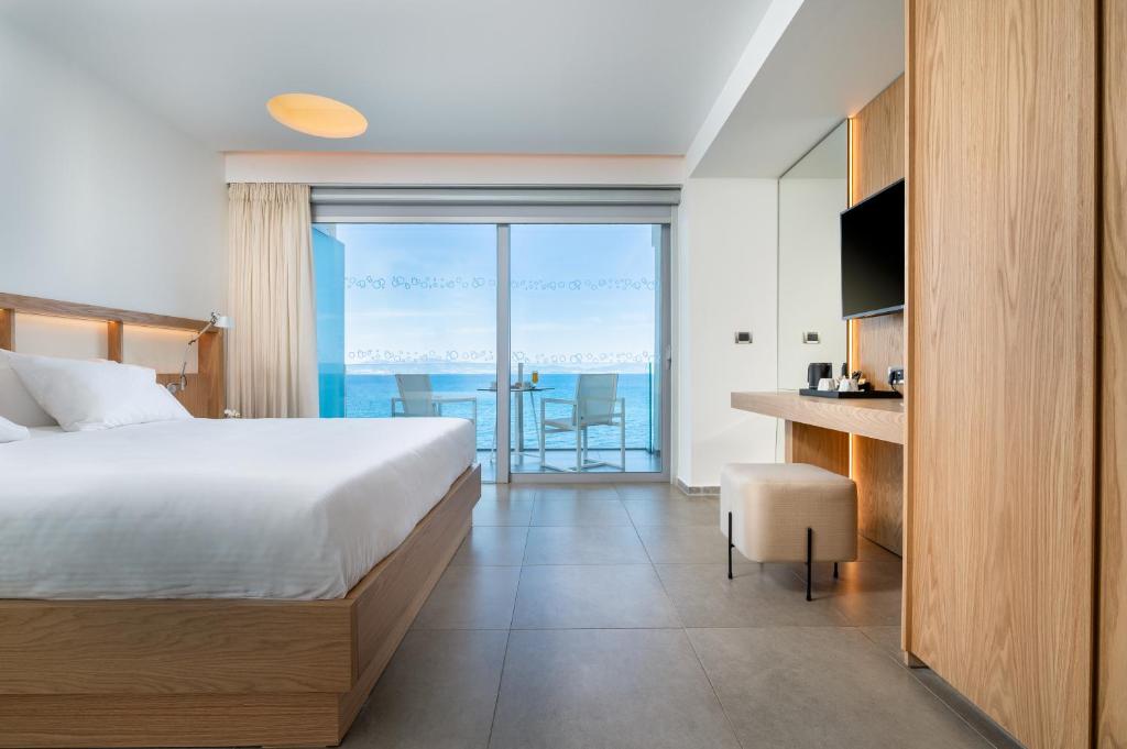 a bedroom with a bed and a view of the ocean at Kos Aktis Art Hotel in Kos