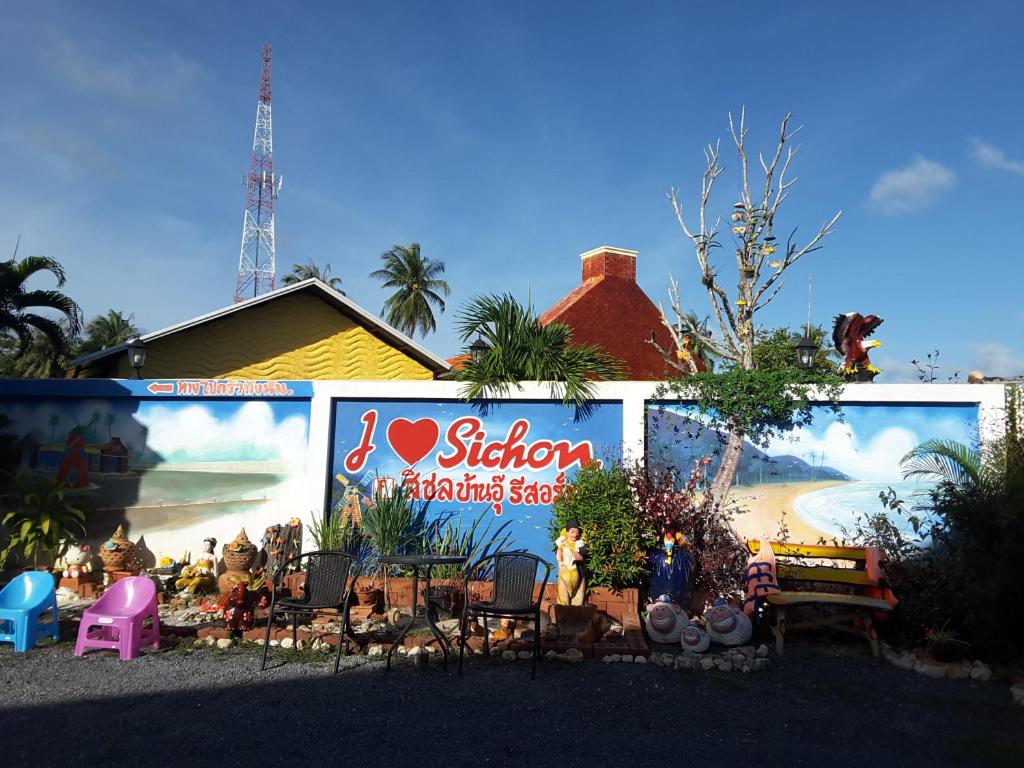 a wall with a large mural of a beach at สิชล บ้านอุ๊ รีสอร์ท in Sichon