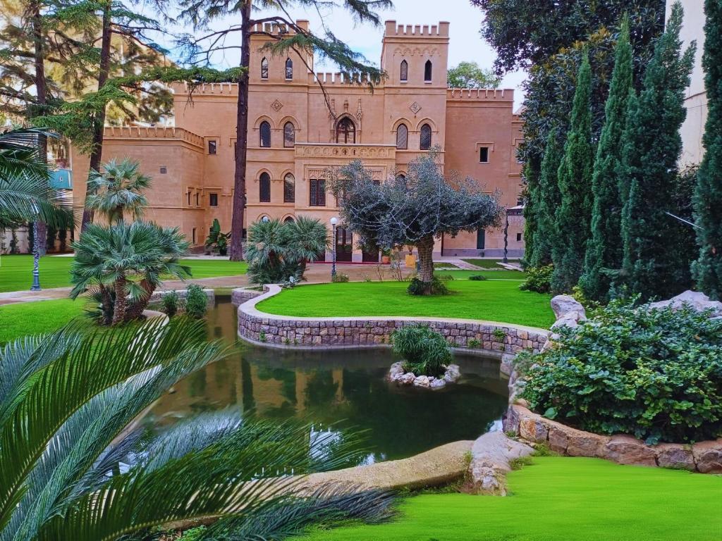 a building with a pond in front of it at Villa Alliata Relais & Spa in Palermo