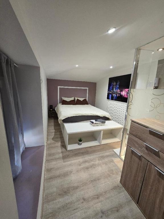 a bedroom with a white bed and a large mirror at Petit studio fief in Le Fief-Sauvin