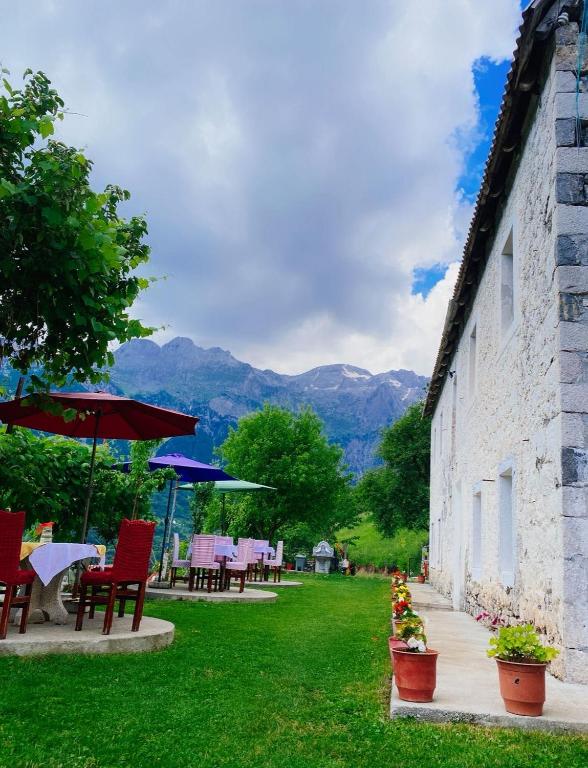 eine Terrasse mit Stühlen und Sonnenschirmen neben einem Gebäude in der Unterkunft The Eagle in Hardedaj