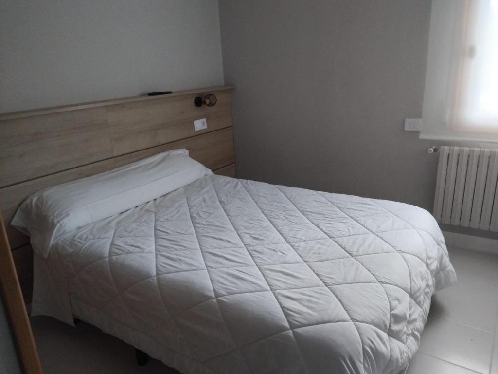 a bedroom with a bed with a white comforter at Ruta Esmeralda in Baamonde