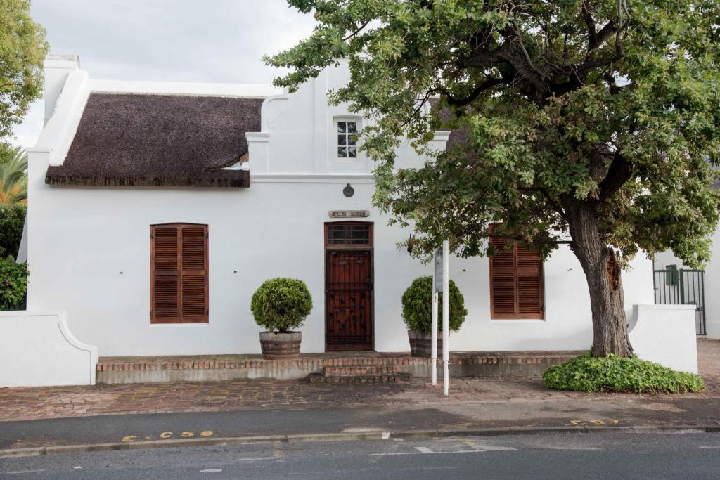 a white house with a tree in front of it at The Prime Spot Self Catering in Worcester