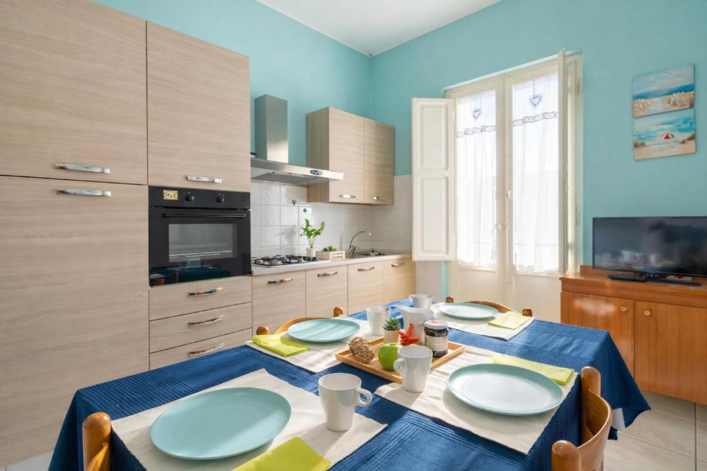 a kitchen with a table with blue plates on it at Terrazza Verdi-Roseto Vacanza in Roseto degli Abruzzi