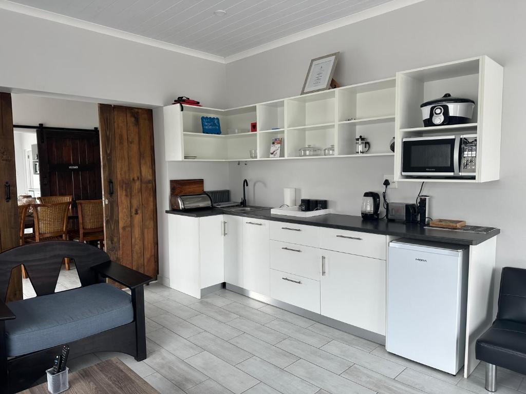 a kitchen with white cabinets and a microwave at The Gallery in Franskraalstrand