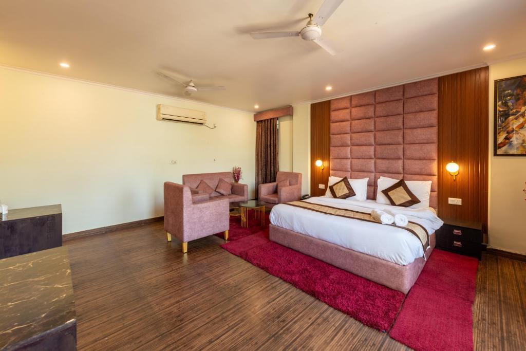 a hotel room with a bed and a desk and chair at La Comfort By shrpl in Gurgaon