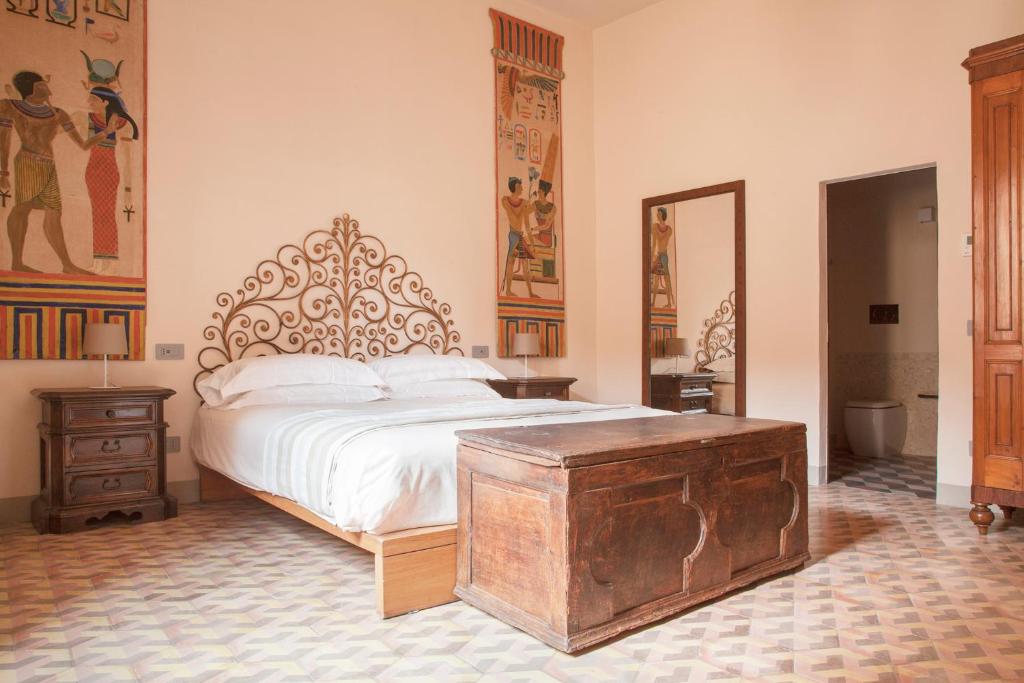 a bedroom with a large bed and a large mirror at Wp Relais Mazzini in Montalcino