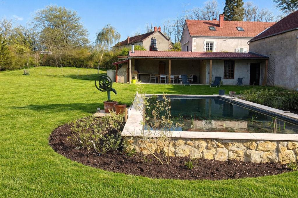 a yard with a swimming pool and a house at Maison Saizy in Monceaux-le-Comte