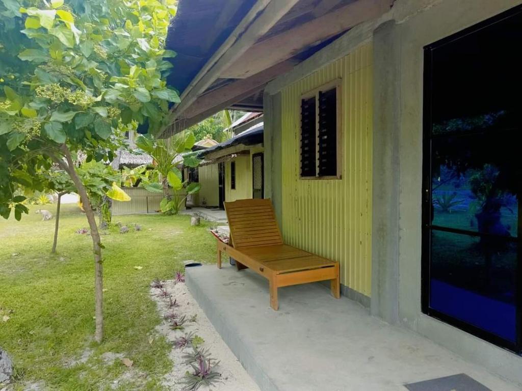 a wooden bench sitting on the side of a house at Coastline Homestay in Burgos