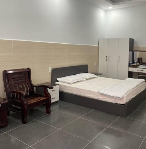 a bedroom with a bed and a chair and a desk at Tú Nguyên Motel in Ban Beng