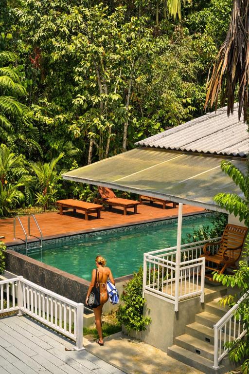 a woman in a bikini standing next to a swimming pool at Django Villa Weligama in Weligama