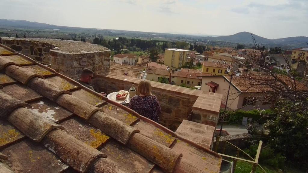 a man and a woman standing on top of a roof at La Torre della Bella Ragazza in Suvereto