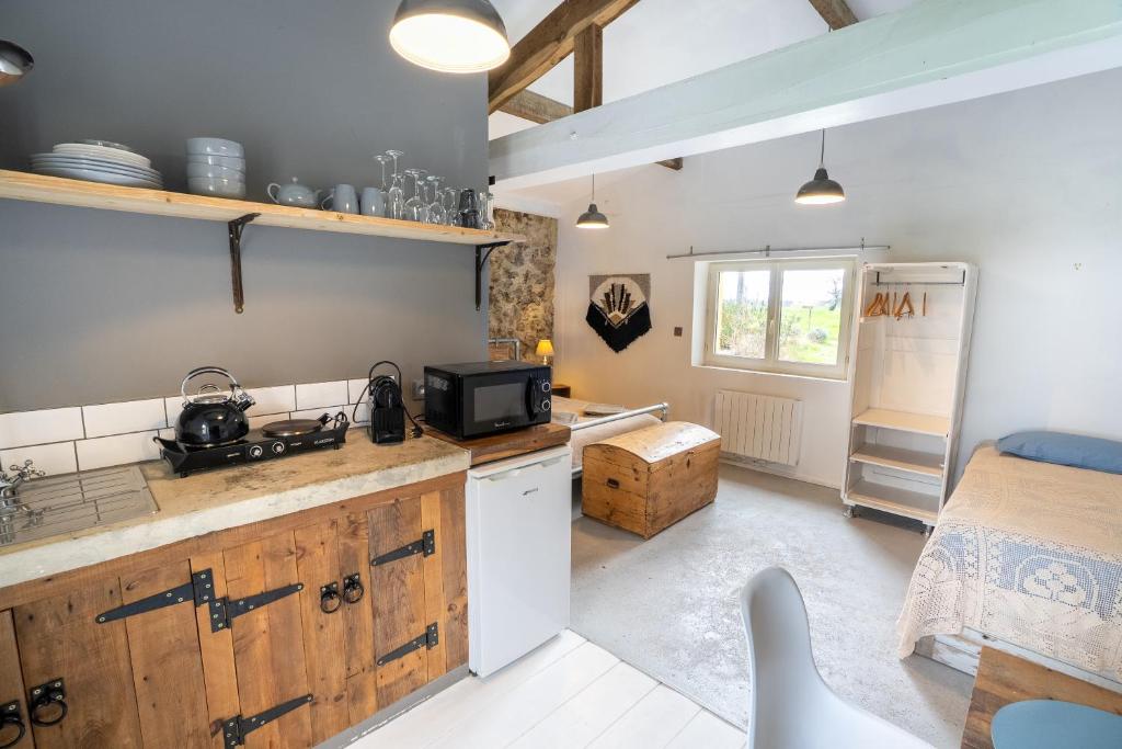 a kitchen with a sink and a refrigerator in a room at Le refuge in Marsalès