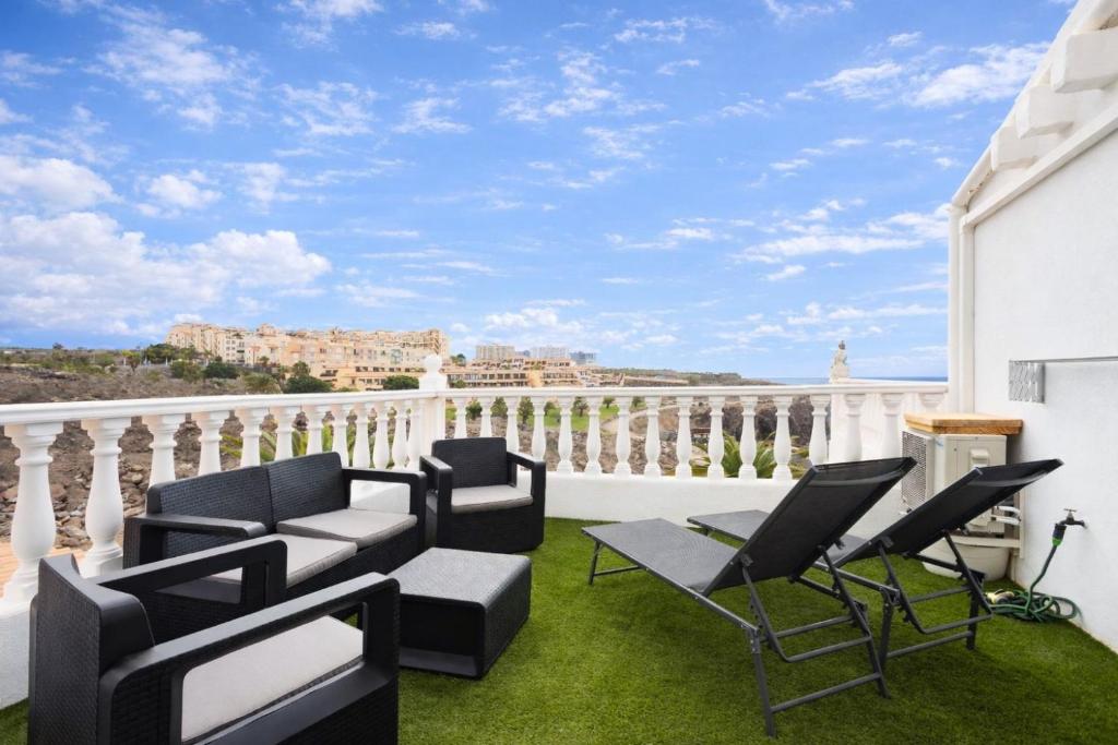 a balcony with chairs and tables on the grass at Happy Home by Olax Rentals in Callao Salvaje