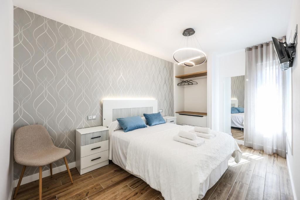 a bedroom with a white bed and a chair at Polán Living | New Apartment - B in Polán