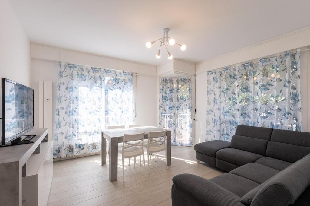 a living room with a couch and a dining room table at Les Fleurs Pool Residence in Bordighera