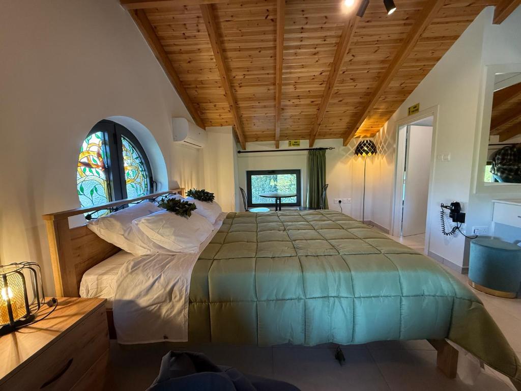 a bedroom with a large bed and a stained glass window at Cyherbia Botanical Park & Labyrinth in Avgorou