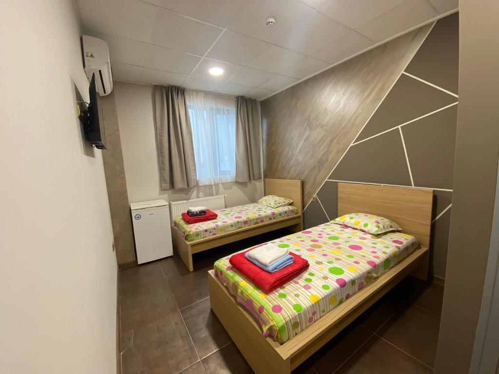 a small room with two beds and a window at Lifto Hostel in Voyvodinovo