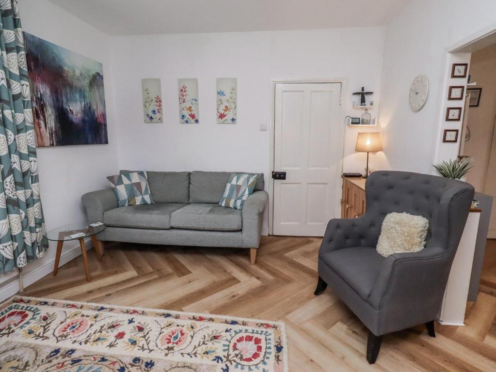 a living room with a couch and a chair at Sea Mist in Newbiggin-by-the-Sea
