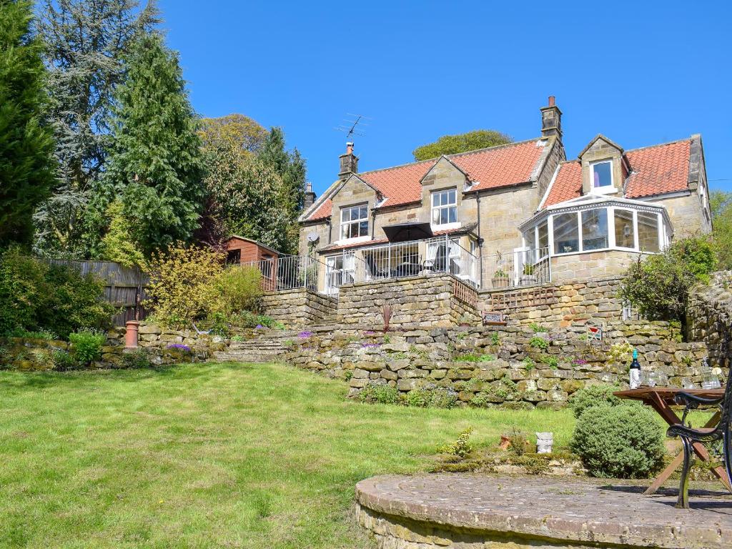 a large house with a stone wall in a yard at Denham in Glaisdale