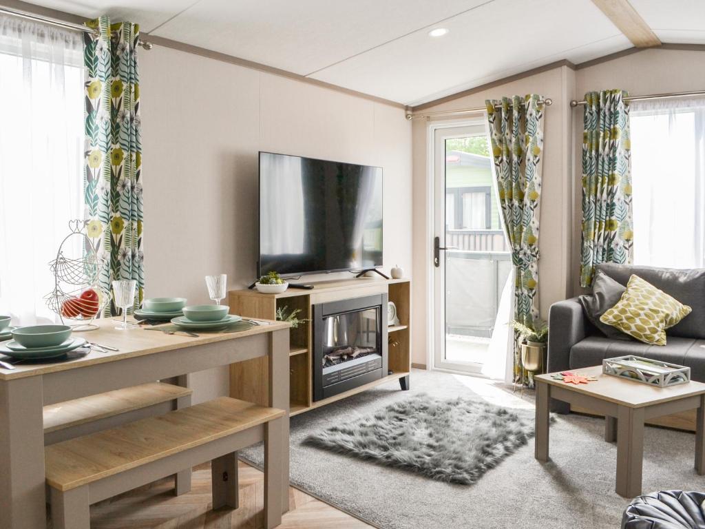 a living room with a tv and a couch at Baywood View in East Heslerton