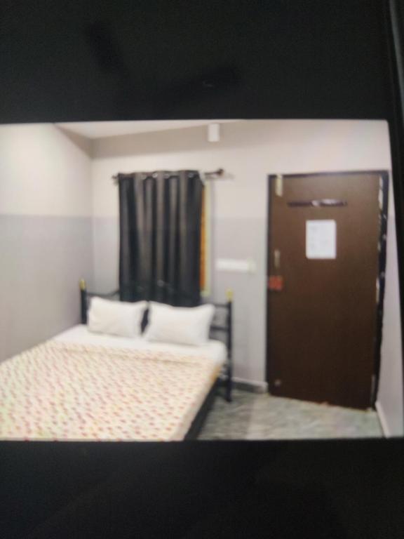 a small room with a bed and a door at Sri Krishnaa comforts in Bangalore