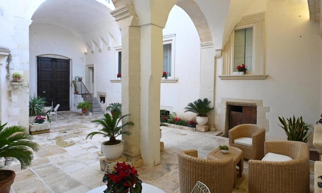 a courtyard with chairs and a fireplace in a building at Dimora San Vito in Lequile